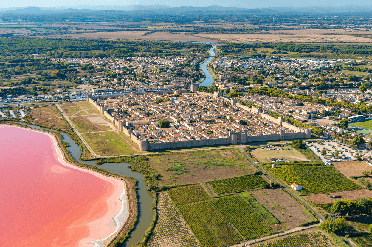 Vue aérienne sur la cité fortifiée d’Aigues-Mortes, le salin rose de Camargue