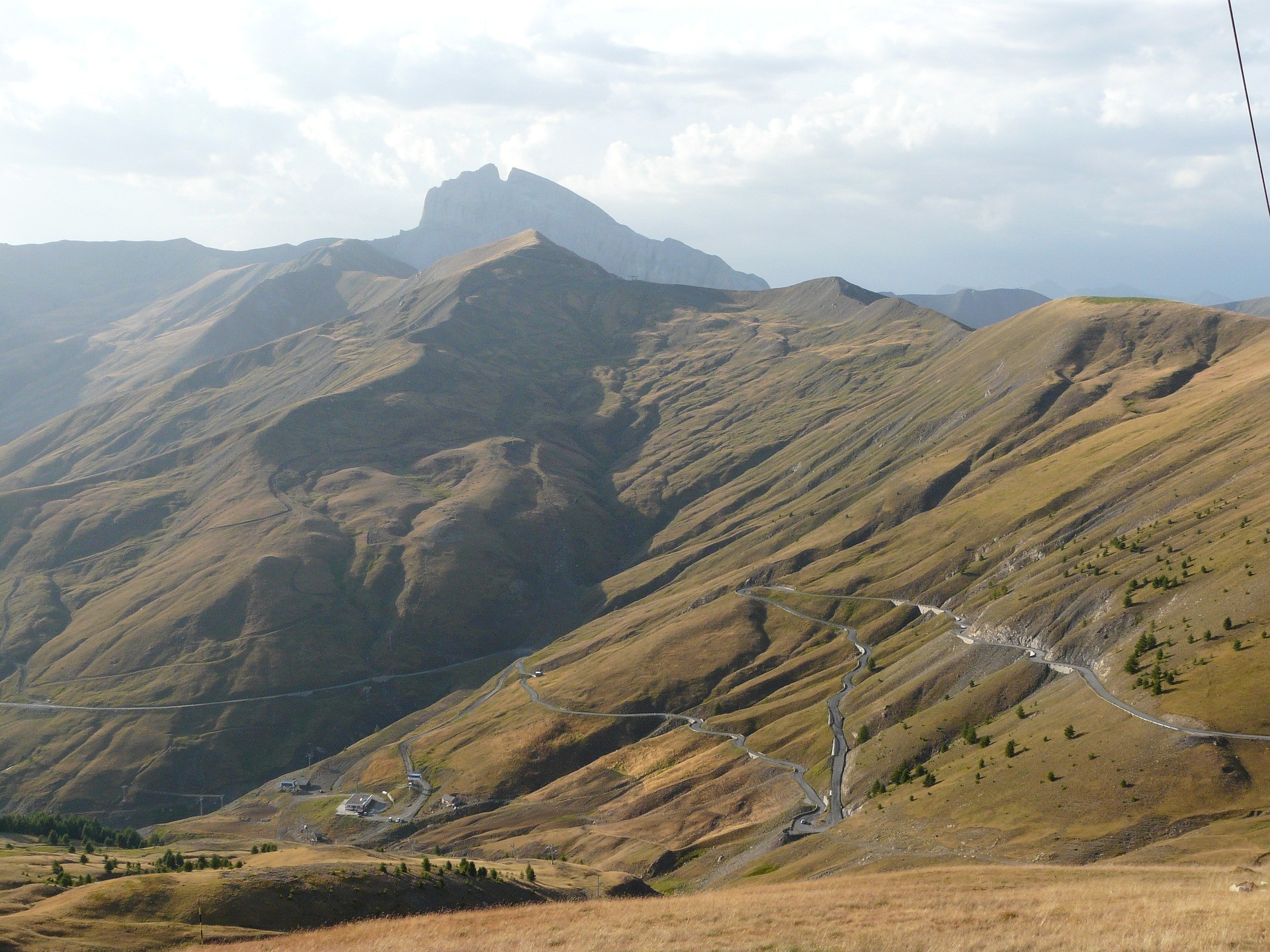 Vue panoramique sur la route du col d’Allos qui serpente au milieu des paysages de montagne des Alpes du Sud au début de l’automne