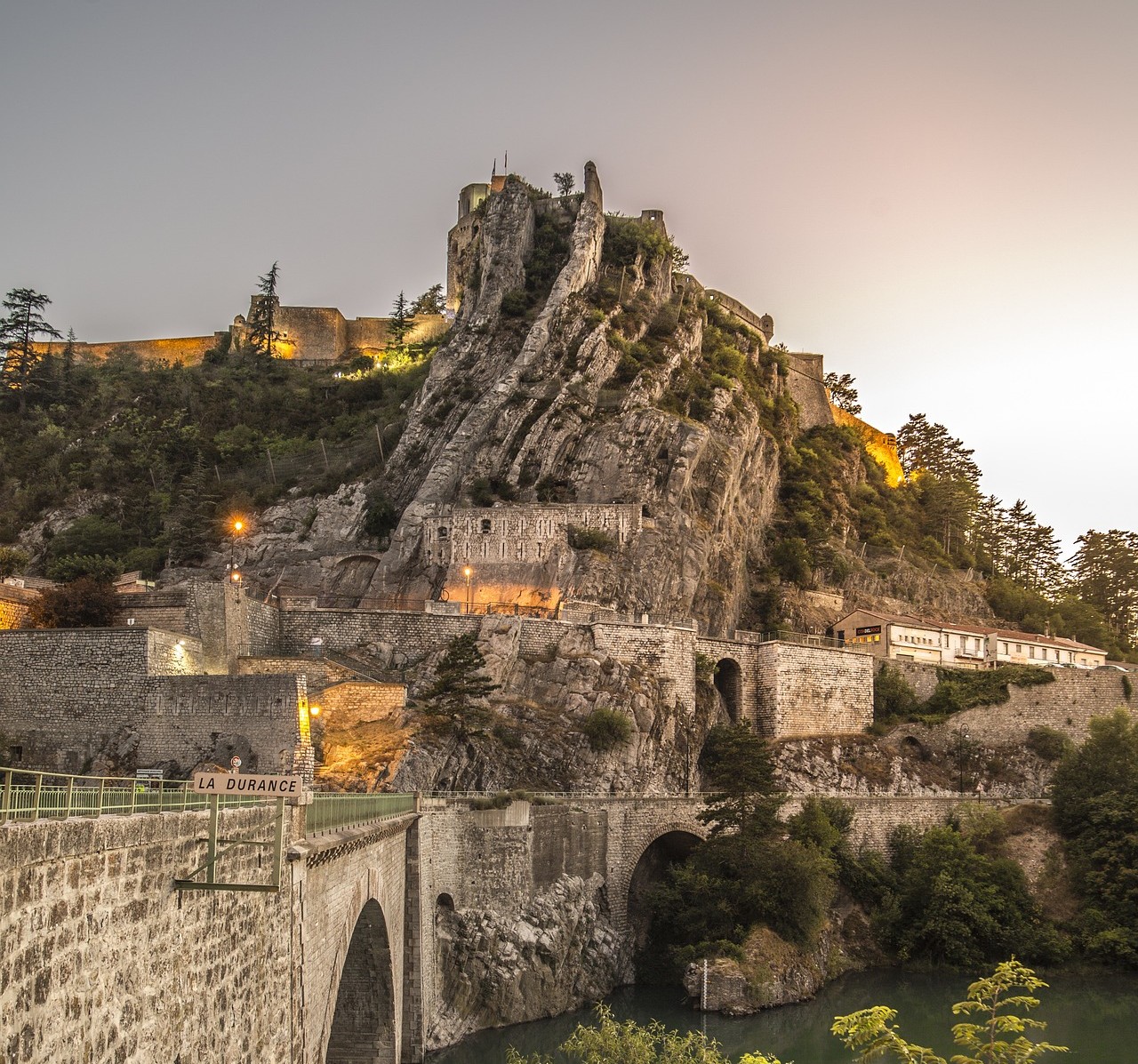 La citadelle de Sisteron sur son éperon rocheux vue depuis le pont de la Durance en fin de journée