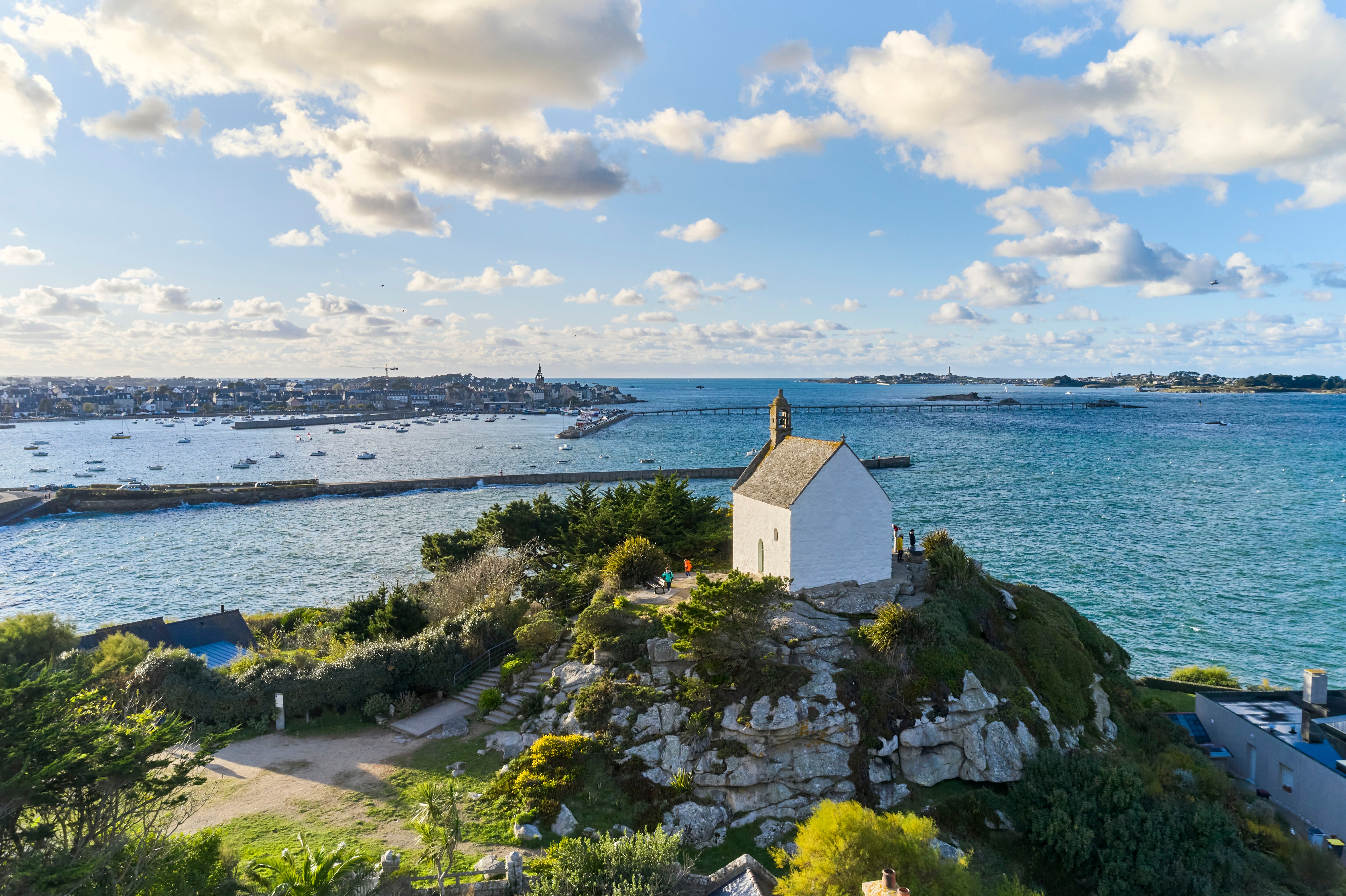 Chapelle sur rocher avec végétation surplombant la mer et le port de Roscoff