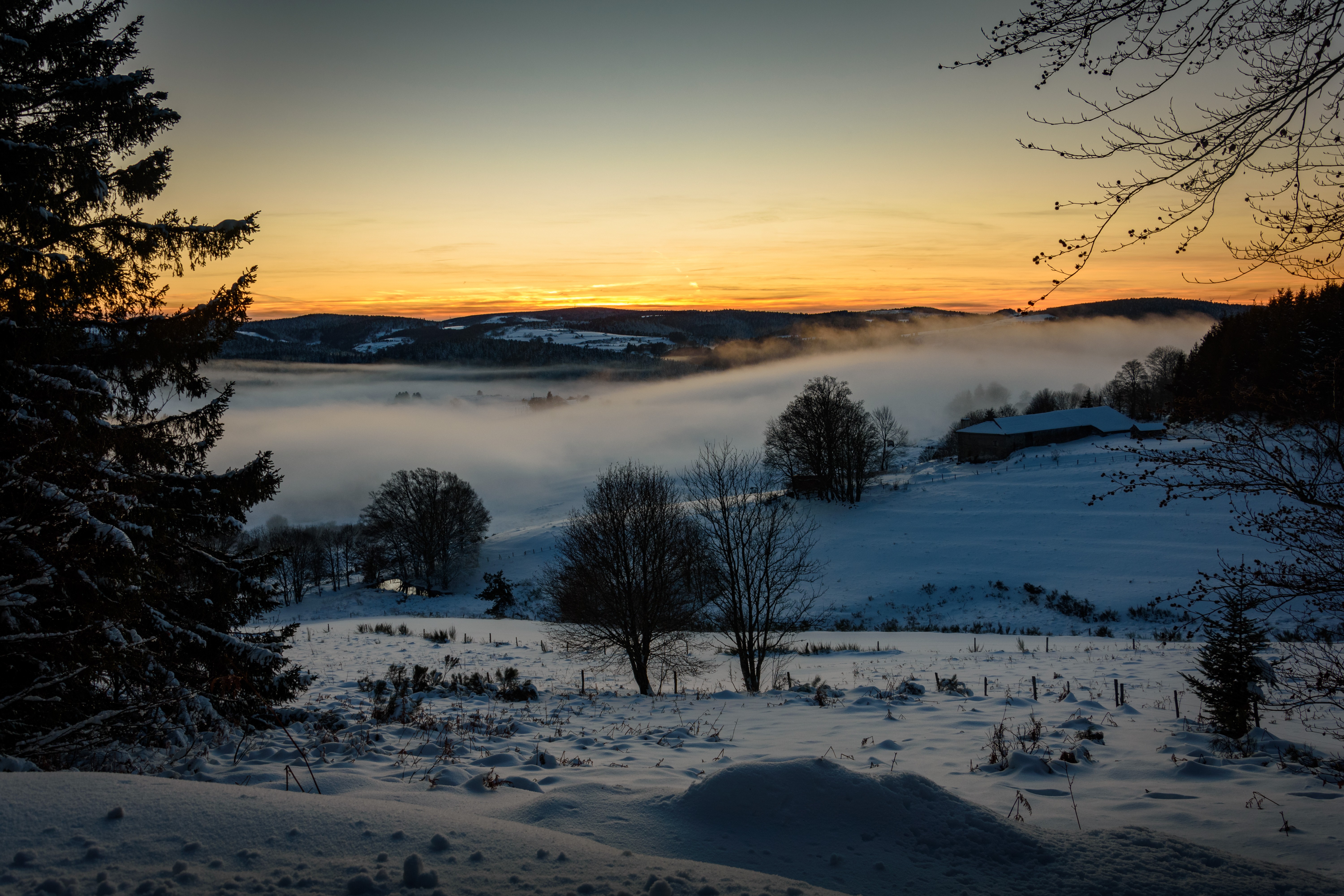 Montagne Ardéchoise au lever du soleil sous la neige et encore sous la brume matinale