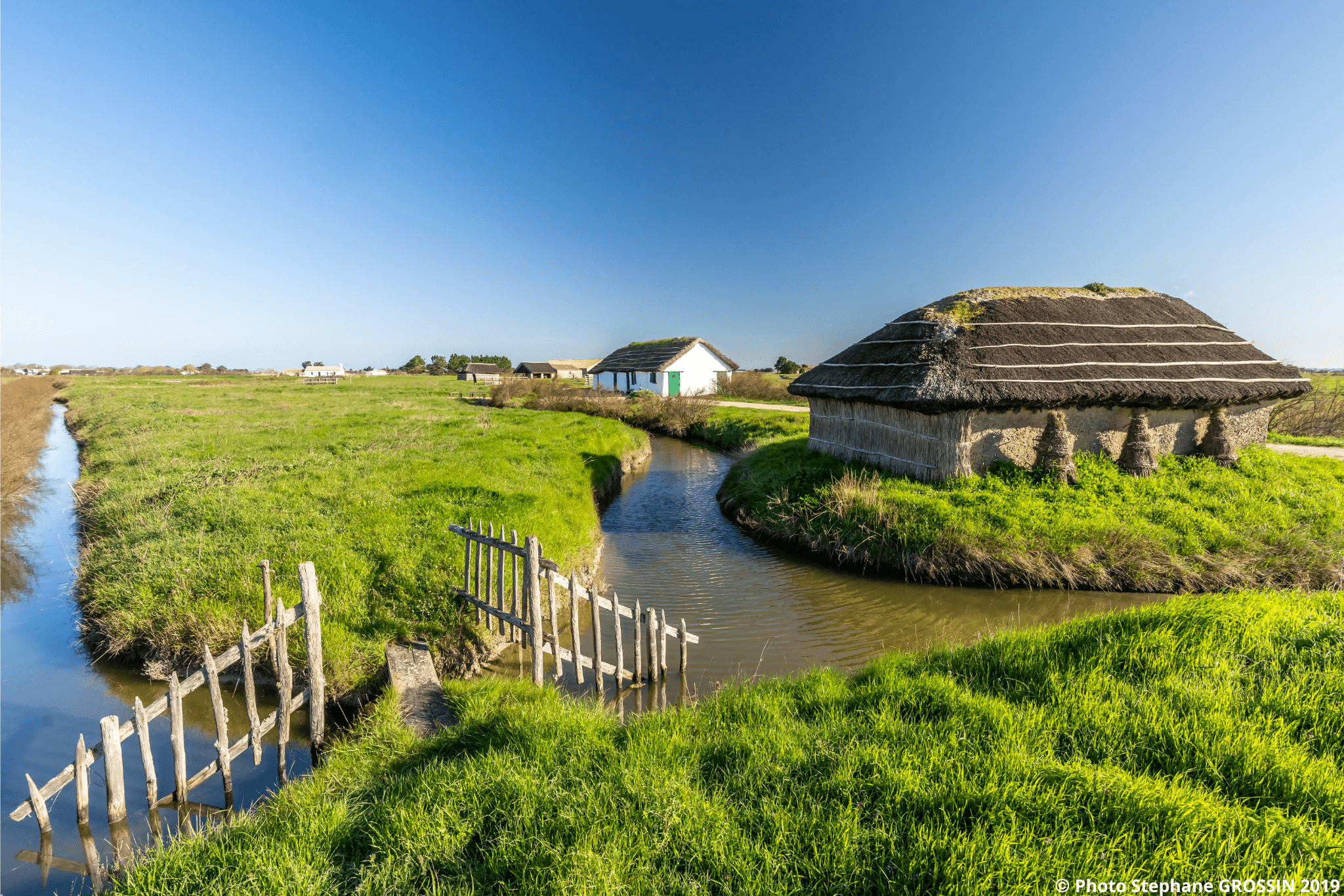 Plusieurs maisons traditionnelles avec toiture en roseaux au bord des marais Breton