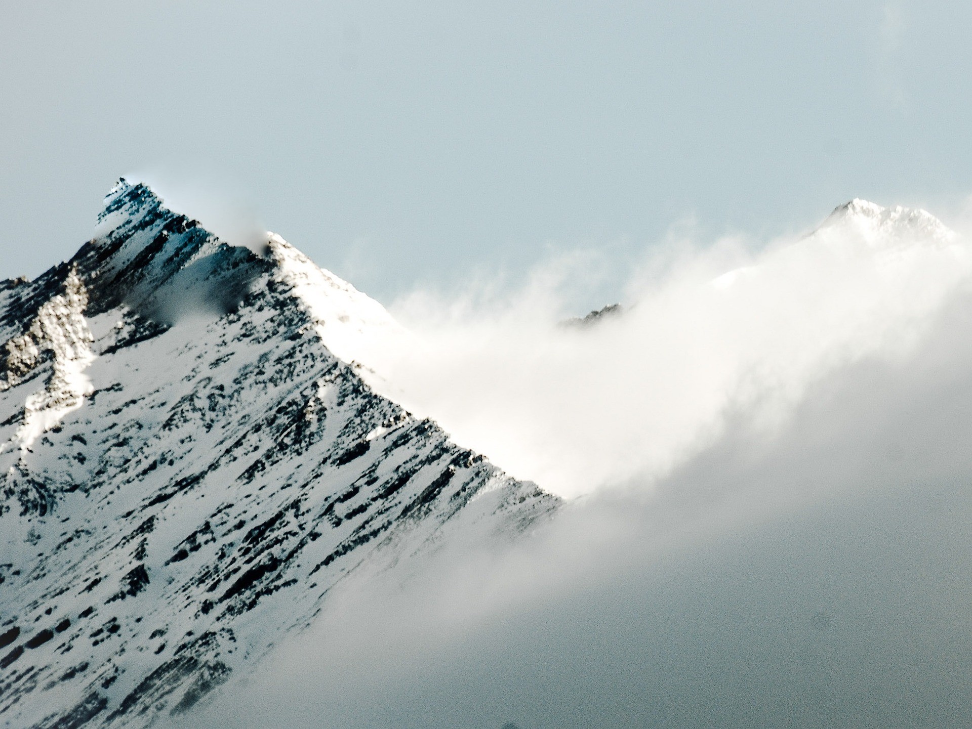 L’un des nombreux sommets enneigés de la vallée de l’Ubaye en saison hivernale avec des nuages accrochés à la montagne