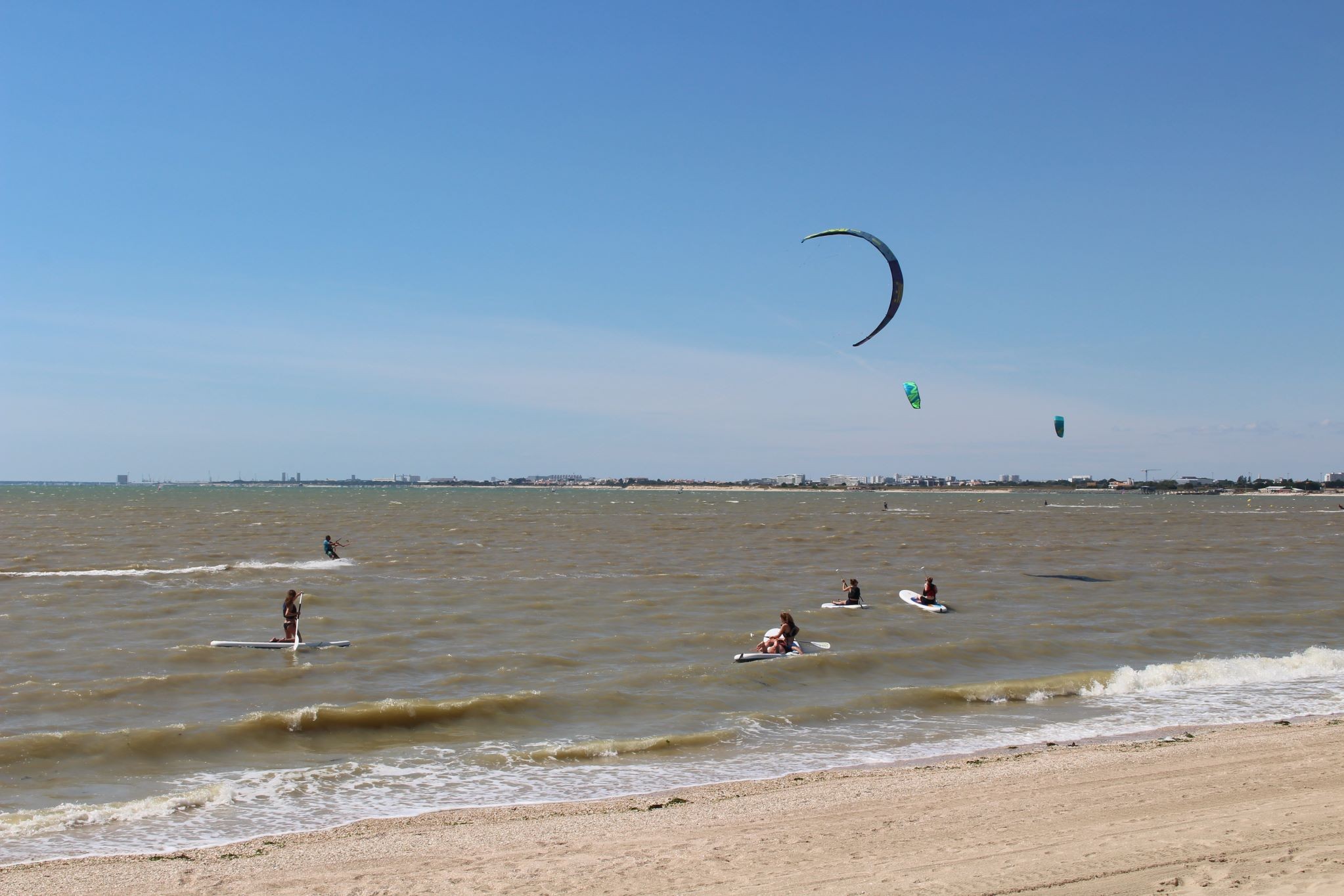 Plusieurs kitesurfeurs qui se laissent porter par le vent très fort sur l’océan
