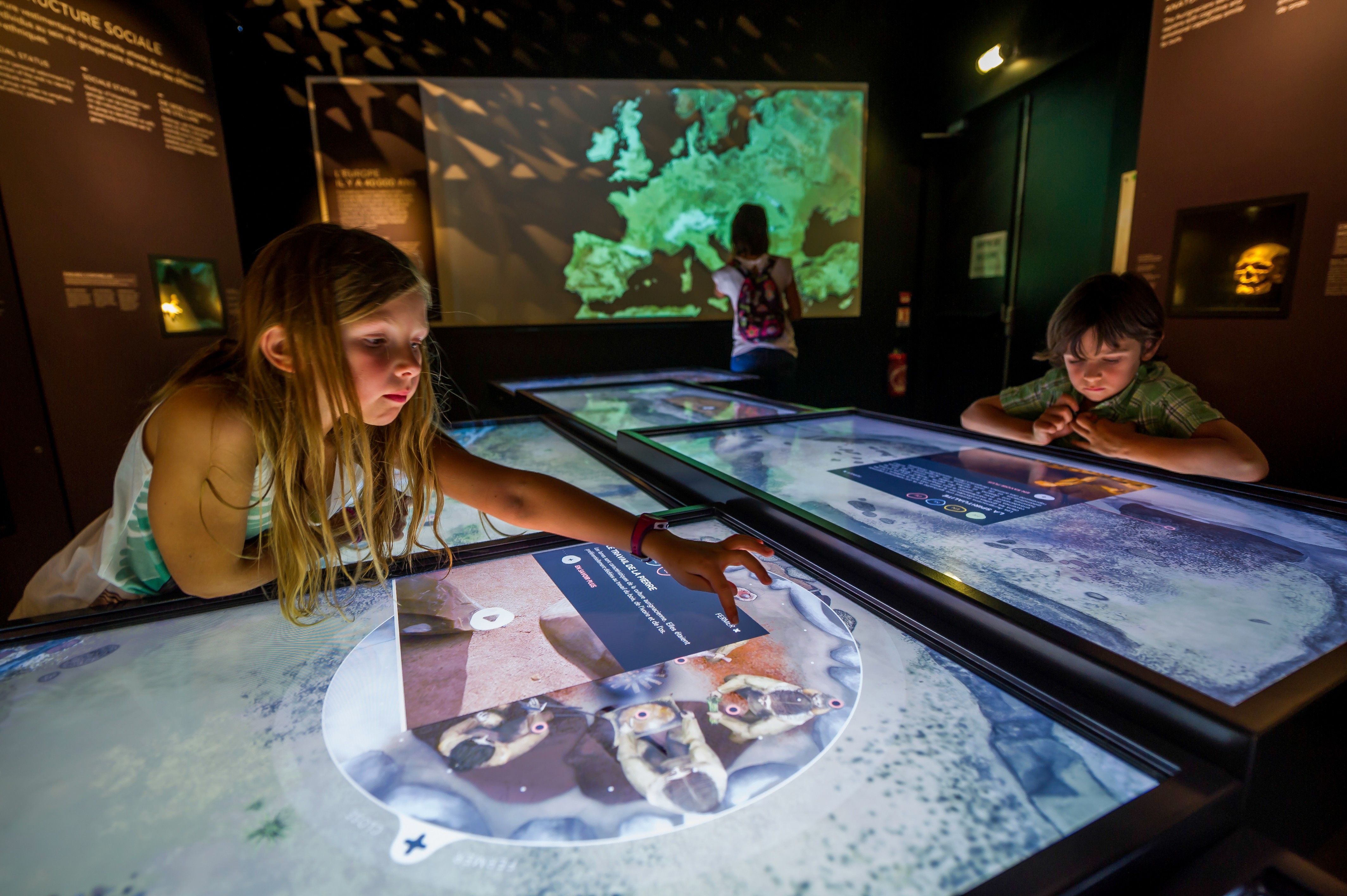 Famille en visite à la Grotte Chauvet - Dans la galerie de l'Aurignacien les enfants profitent des installations ludiques 