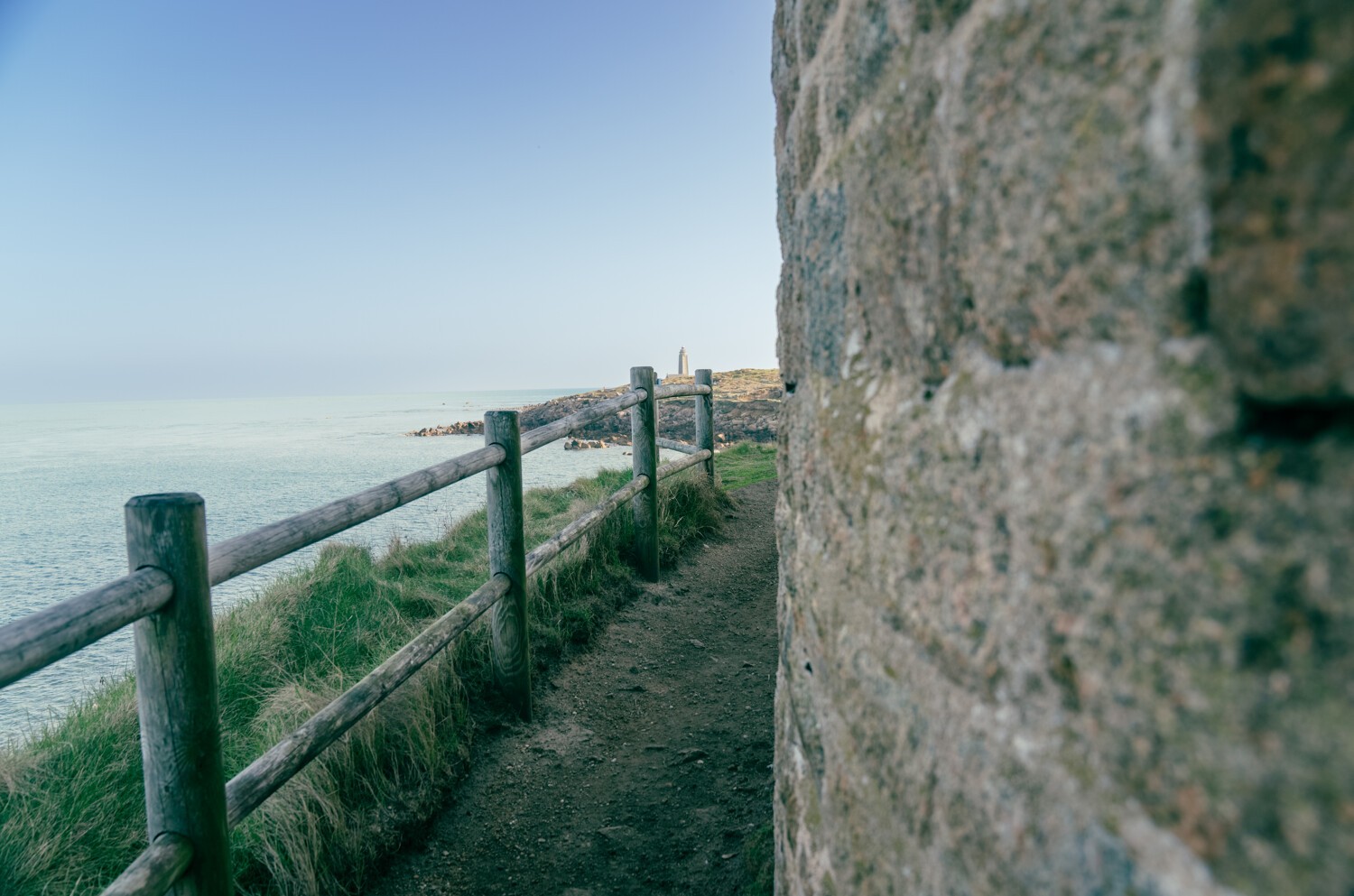 Randonneuse, GR223, pierres, chemin, falaise au-dessus de la mer bleue, ciel bleu nuageux 