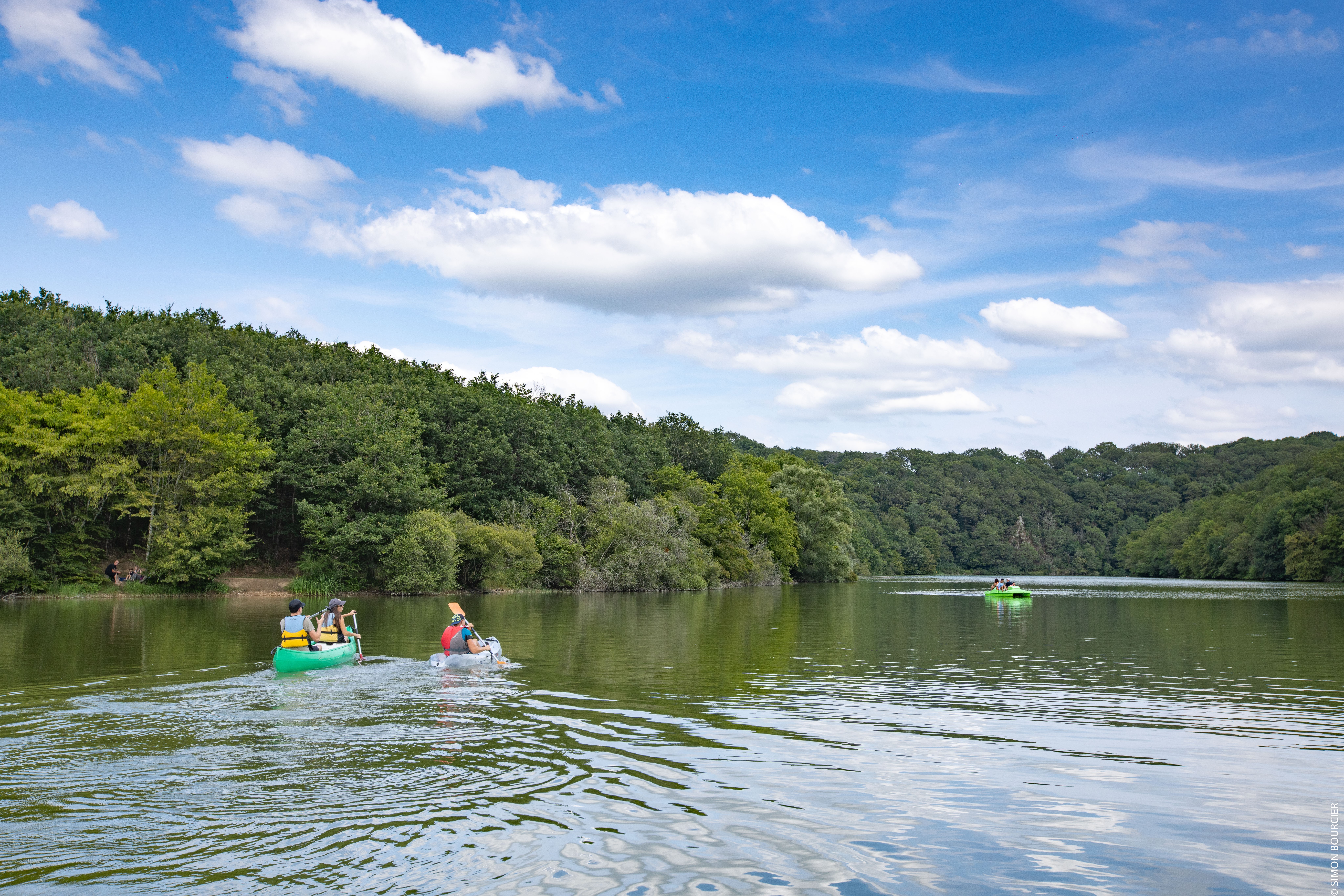 Personnes pratiquant le canoë sur le lac de Mervent avec la forêt à perte de vue