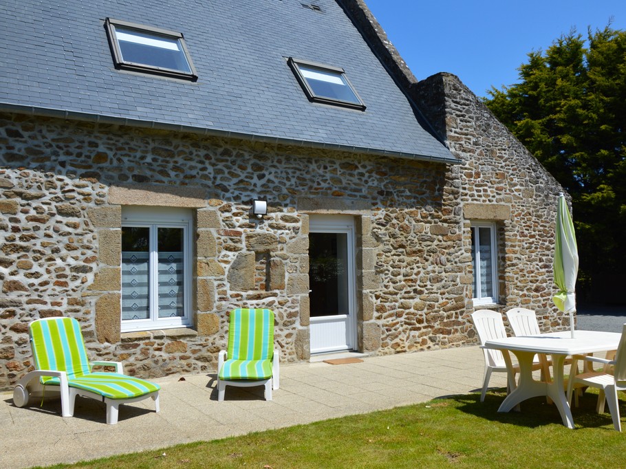 Façade en pierre du Gîte 2 avec terrasse, jardin, balançoire, bac à sable et stationnements privatifs. Accès indépendant.