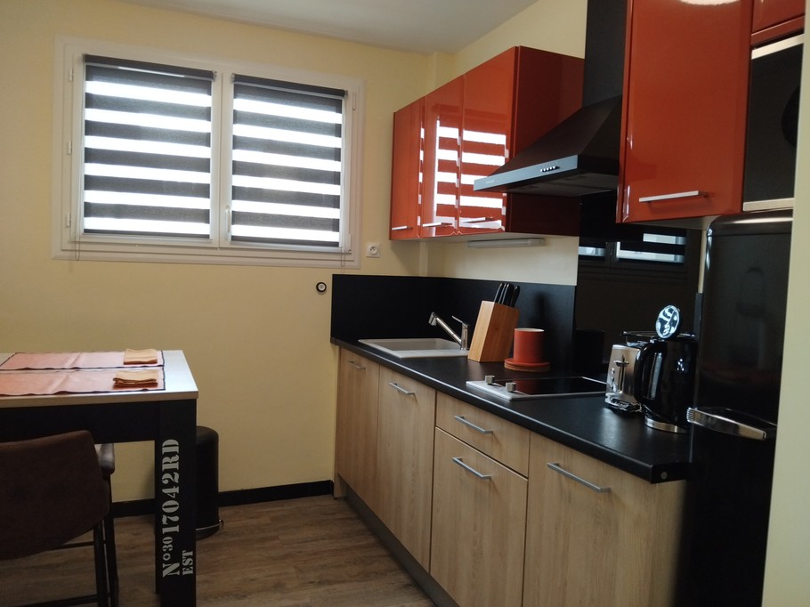 Une cuisine indépendante équipée et aménagée avec la table pour les repas