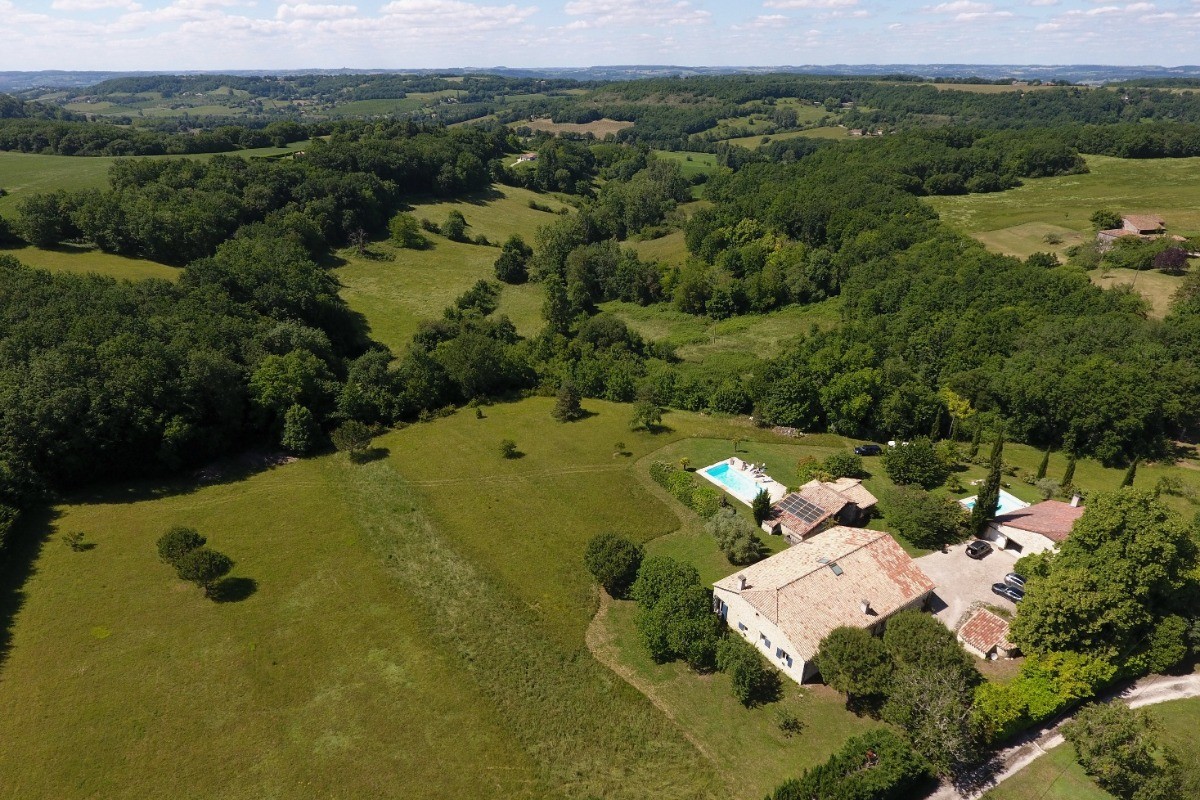 Le gîte et sa piscine sont en premier plan, la maison des propriétaires à l'arrière