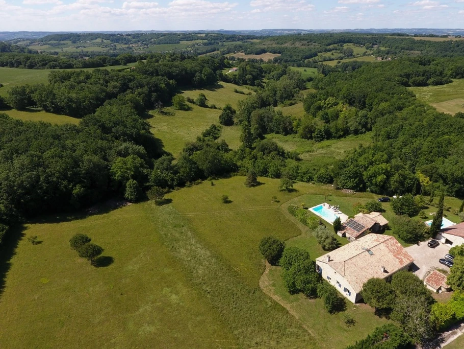 Le gîte et sa piscine sont en premier plan, la maison des propriétaires à l'arrière