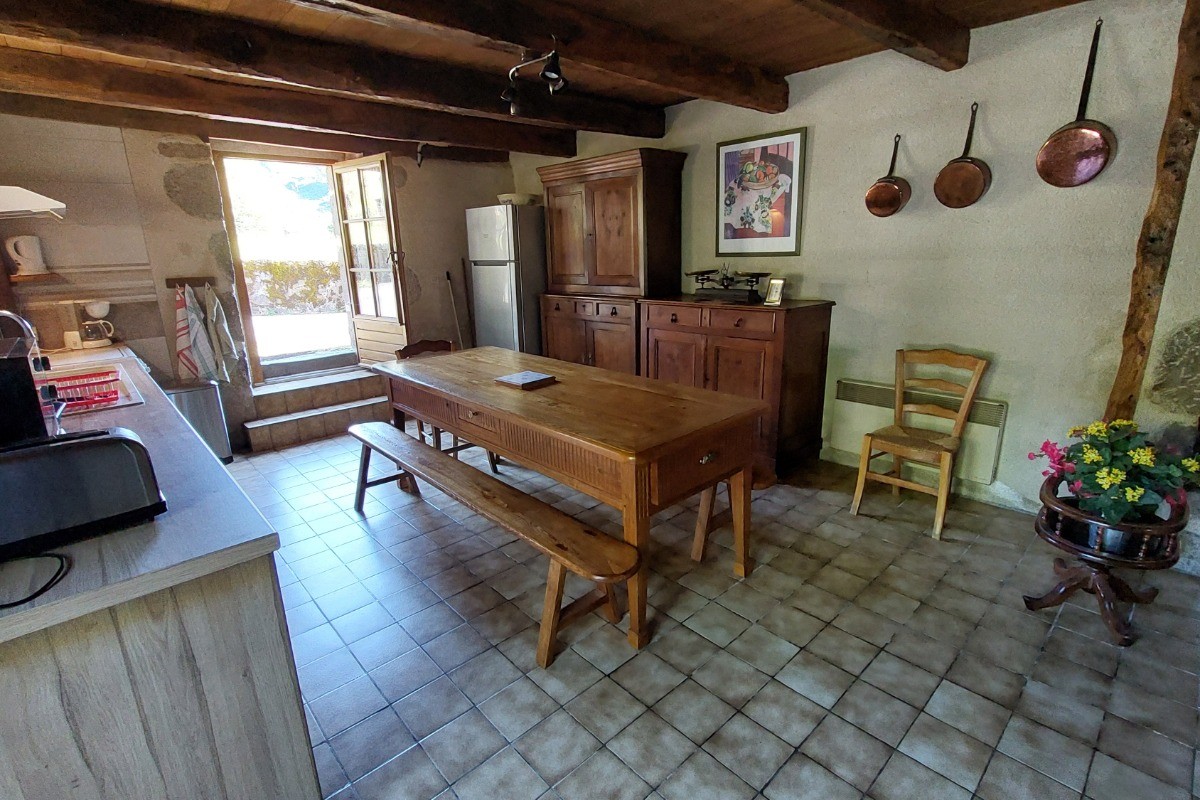 Cuisine équipée avec table à manger pour 6 personnes, idéale pour des repas conviviaux en famille.