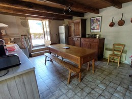 Cuisine équipée avec table à manger pour 6 personnes, idéale pour des repas conviviaux en famille.