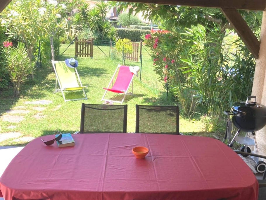 La terrasse couverte côté jardin avec table et chaises pour les repas et la détente en extérieur.