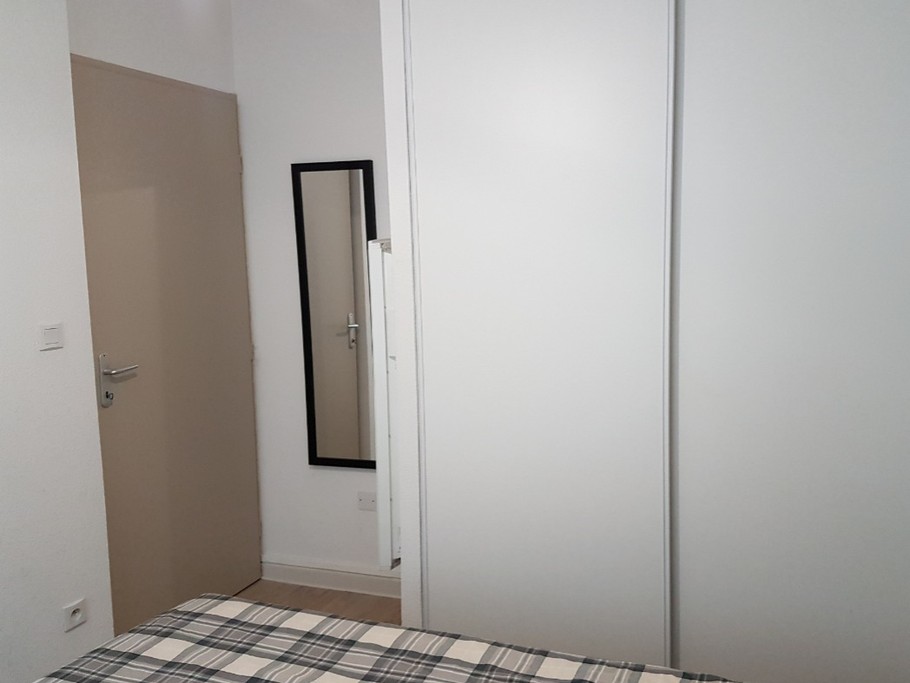 Chambre 1, placard aménagé (étagères, penderie), patère, valet de chambre (non visible sur la photo)