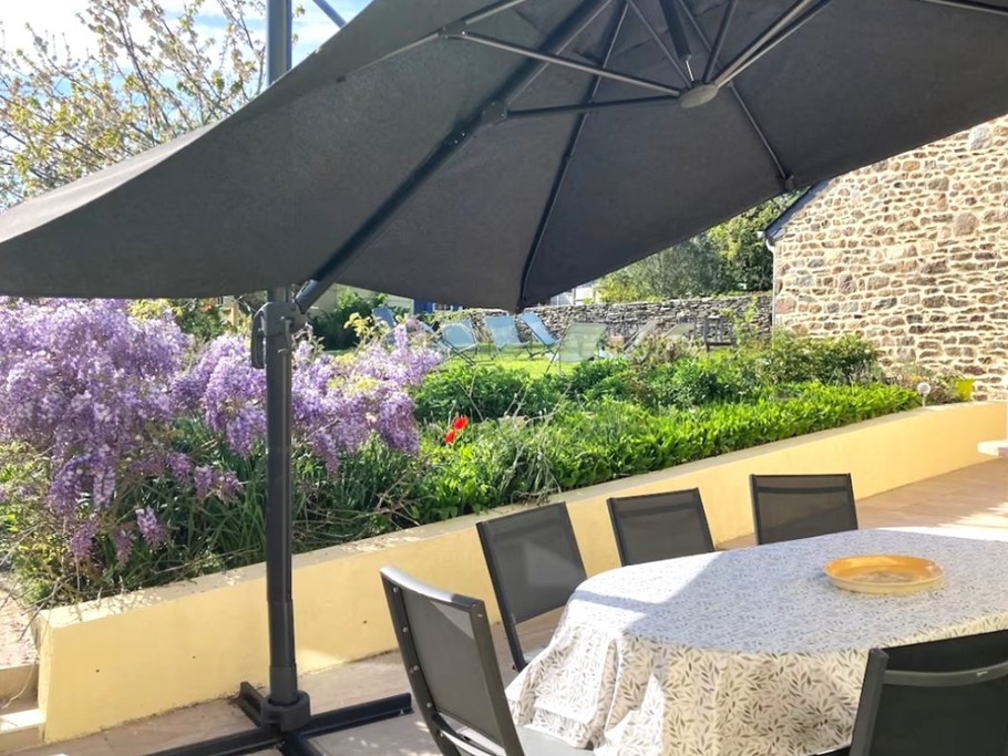 Terrasse avec table de jardin, parasol, barbecue, plancha, four à pizza