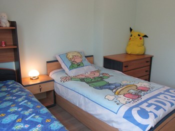 Chambre enfants avec une commode et placard-rangement.