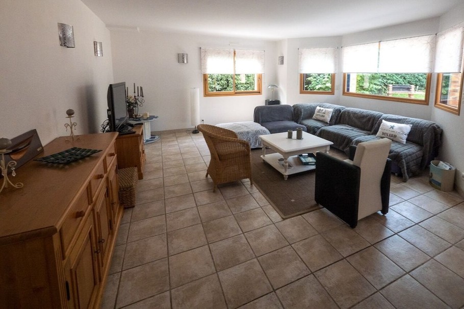 Grande pièce de vie lumineuse avec accès jardin. Coin salon.