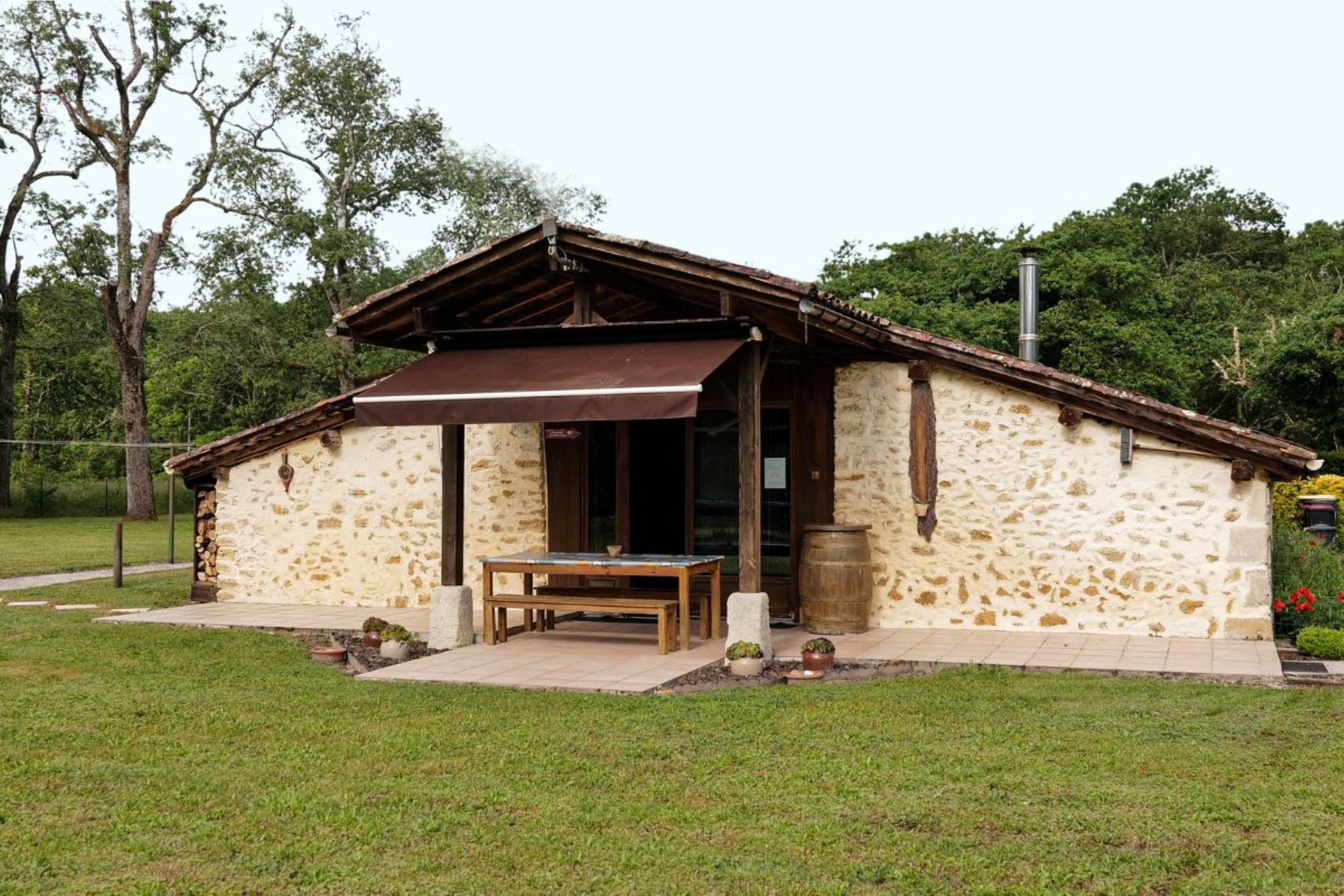 La façade de La Bergerie avec la terrasse et son auvent pour s'abriter du soleil, Gironde