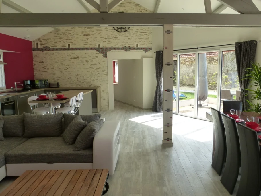 Living room with sofa bed, dining table, central island and fully equipped kitchen.