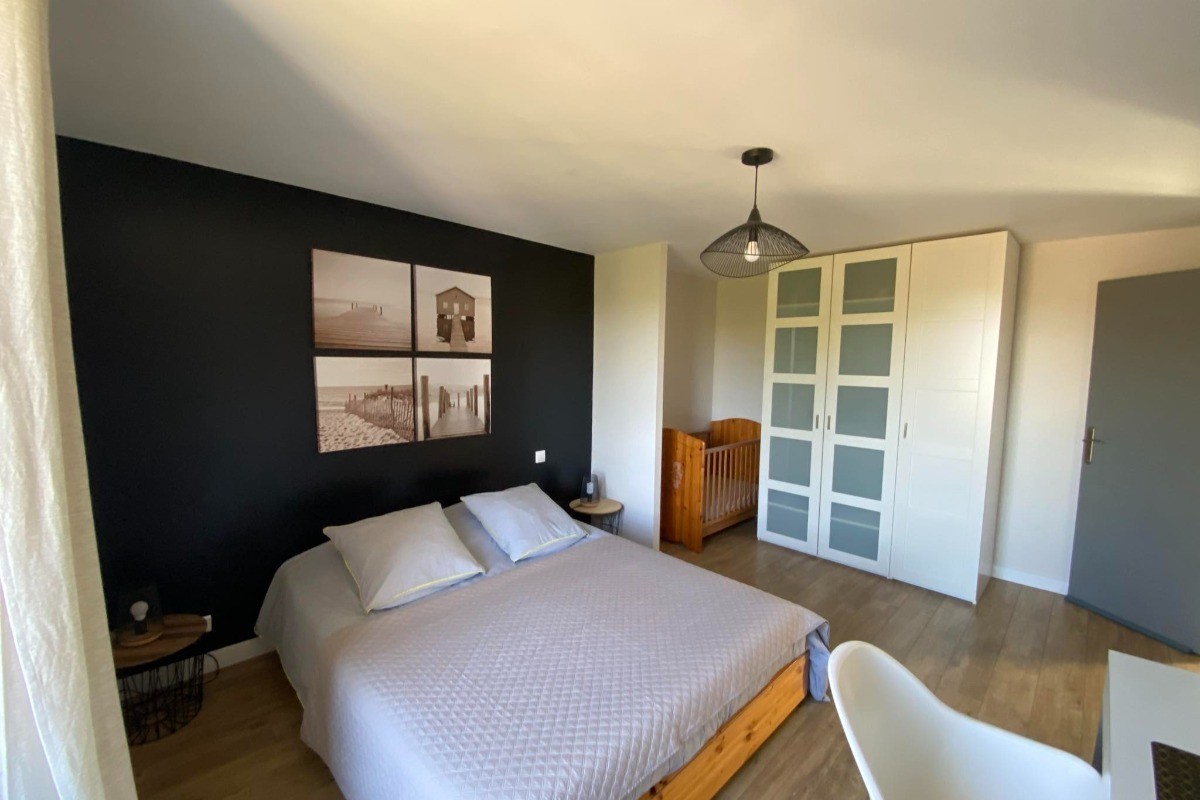 Chambre parentale avec lit bébé, bureau et grand placard