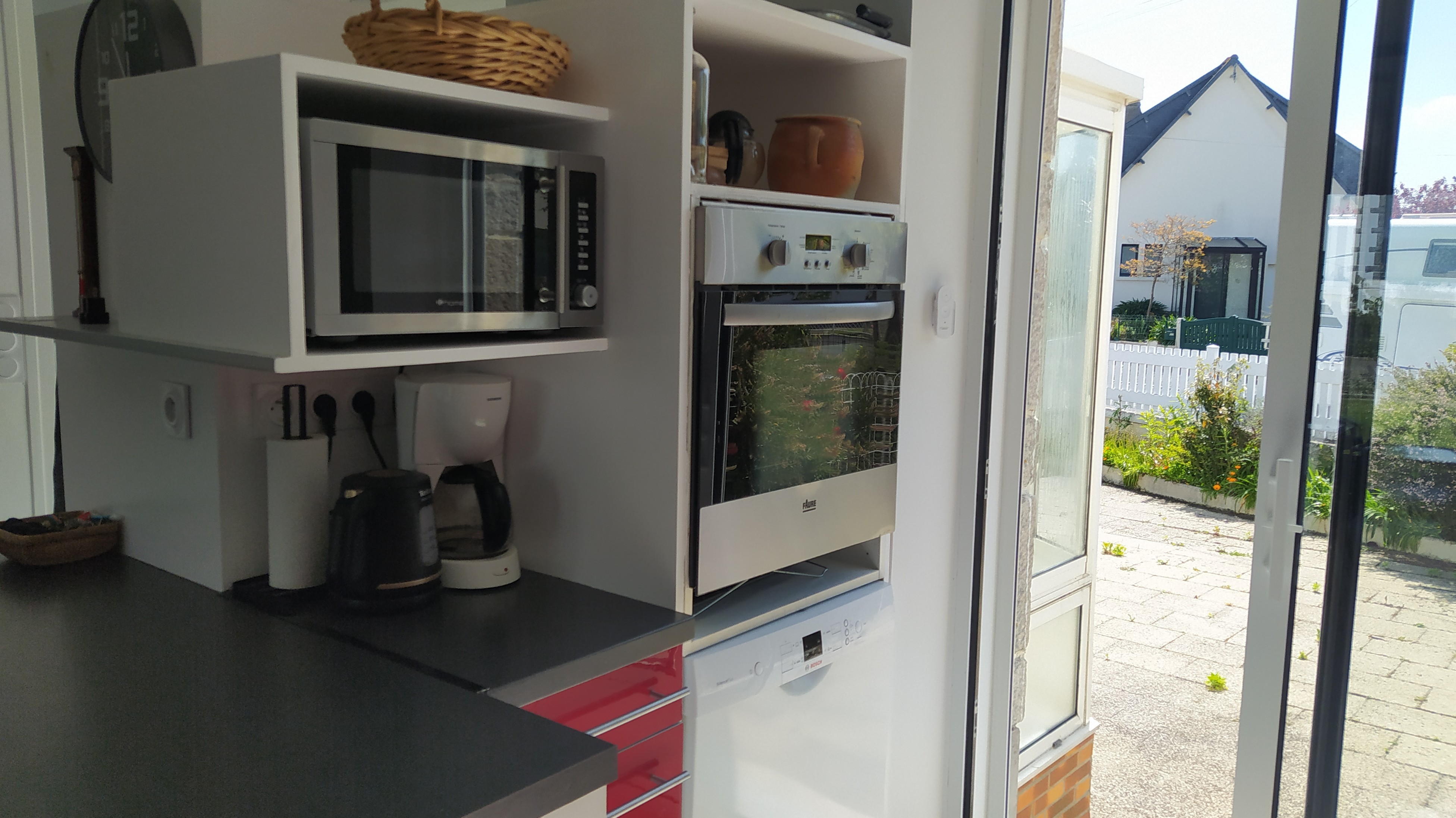 Pièce de vie au RDC avec entrée, cuisine, séjour, salon et poêle à bois.