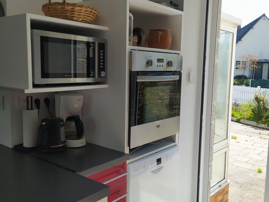 Pièce de vie au RDC avec entrée, cuisine, séjour, salon et poêle à bois.