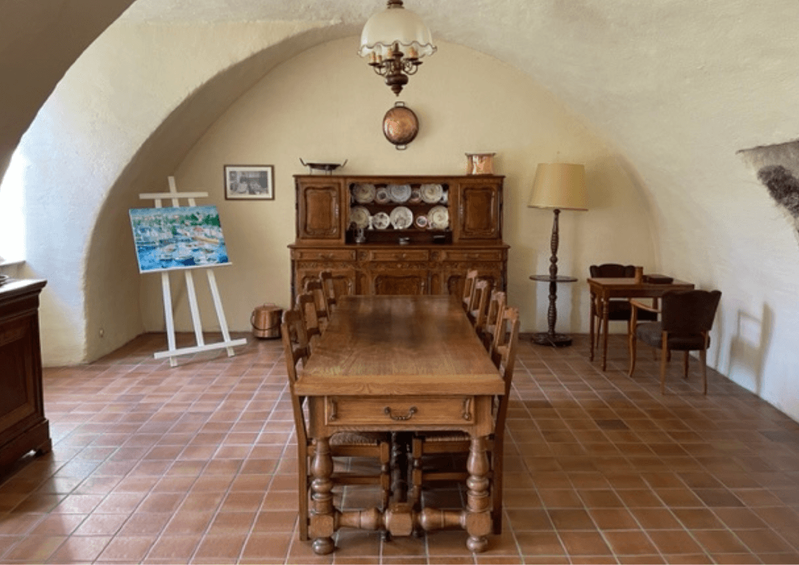 Salle à manger voûtée avec table de jeux et ambiance chaleureuse dans une demeure historique