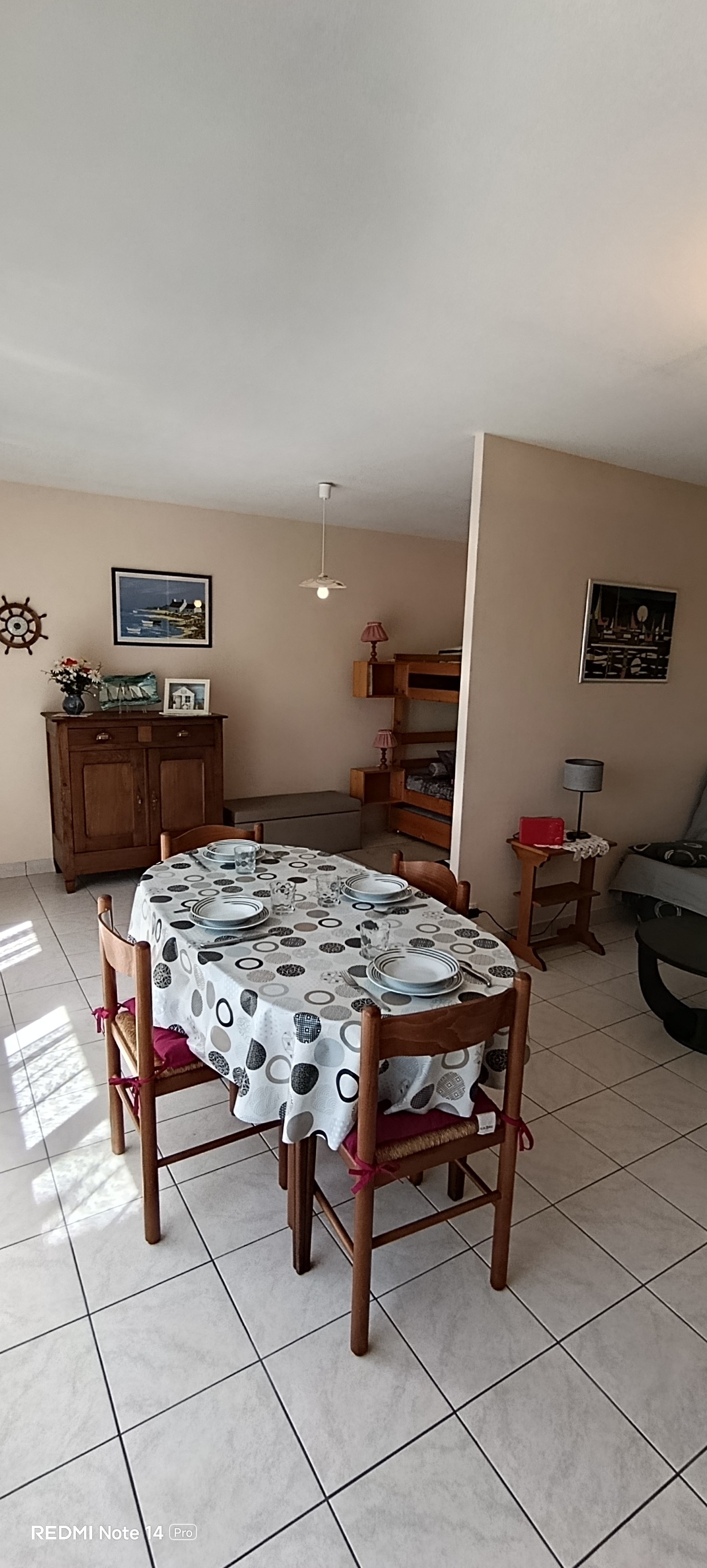 The dining area and sitting area in the living room. At the back on the left, the two bunk beds – “Le Beaulieu” flat