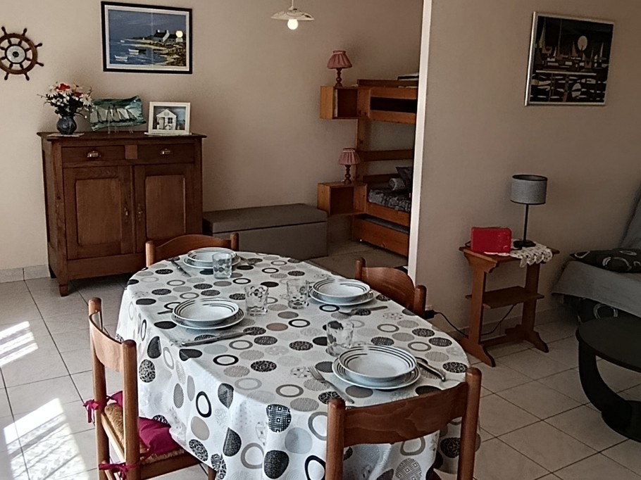The dining area and sitting area in the living room. At the back on the left, the two bunk beds – “Le Beaulieu” flat