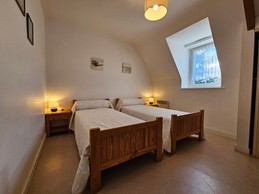 Chambre indépendante pour 2 personnes avec 2 lits 90x190 cm, commode, armoire et chaise.