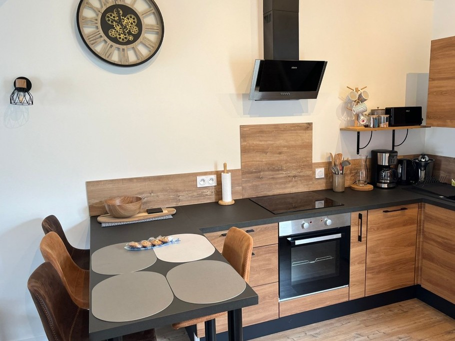 Pièce de vie spacieuse avec une belle hauteur sous plafond. Coin cuisine et coin salon.