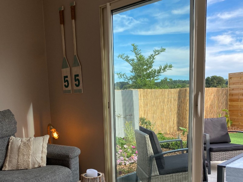 Le Gîte 55, Clévacances, location Paimpol, salon avec baie vitrée sur la terrasse privative