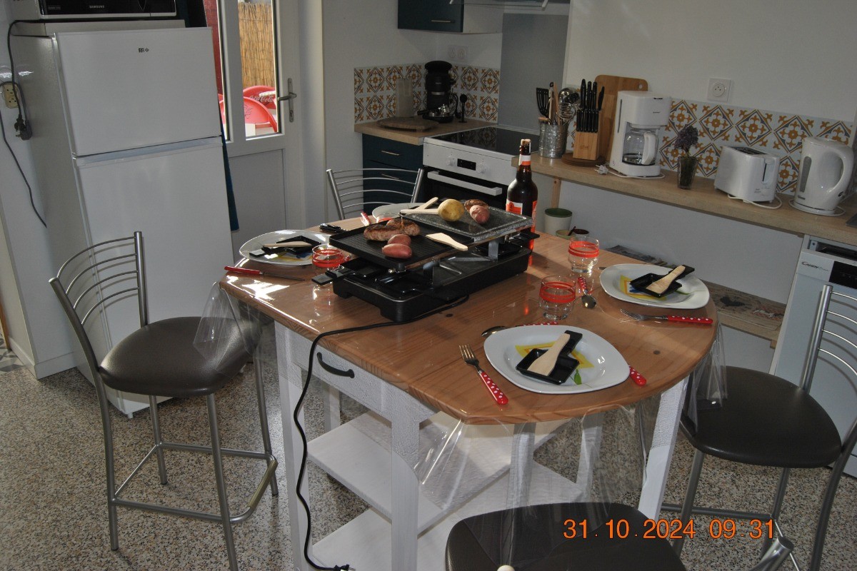 Un appareil de convivialité 3 en 1 (raclette, grill, pierrade) pour un petit repas d'automne sur une table haute et les 4 chaises.