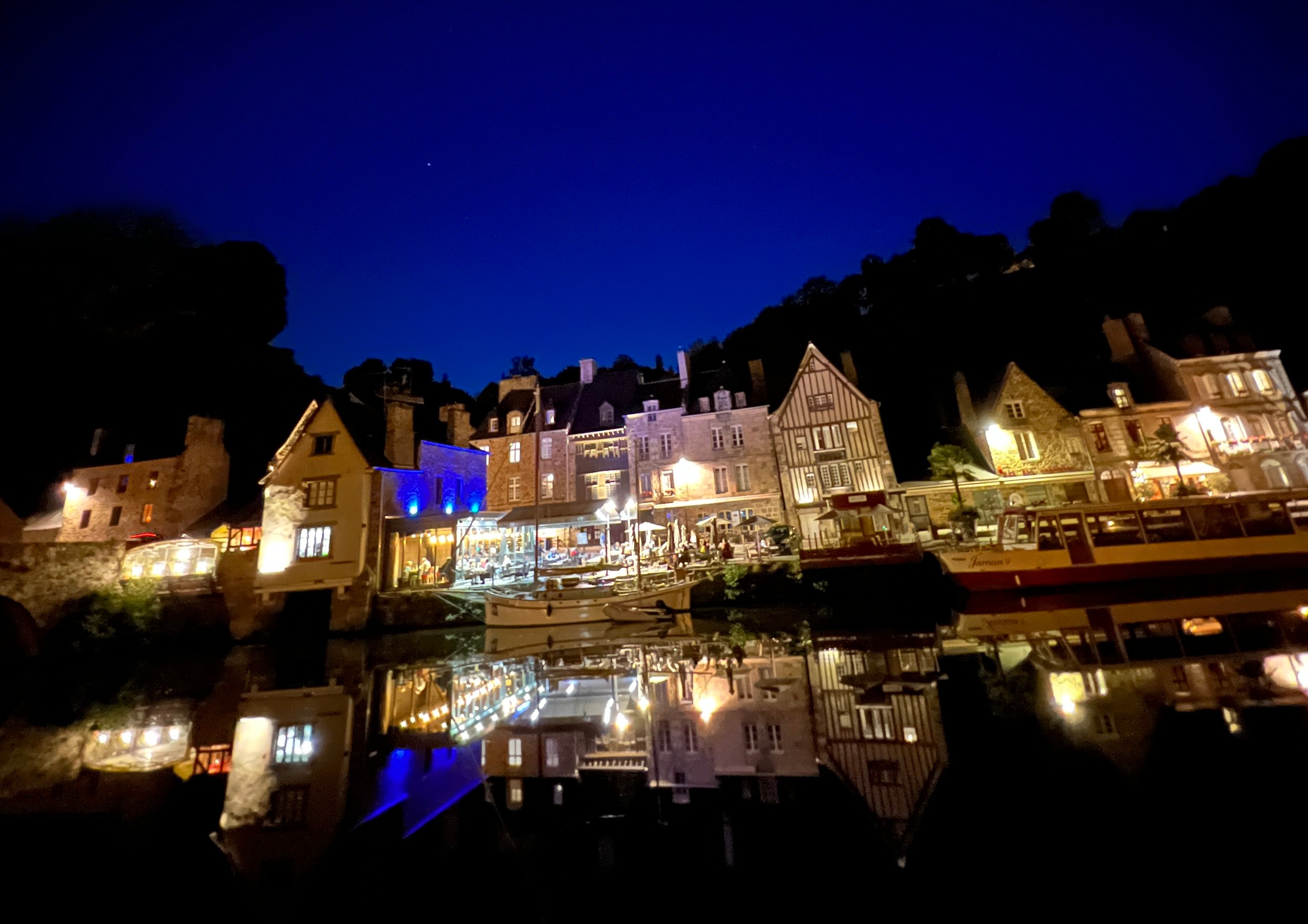 Magical evening atmosphere at Dinan Port with lights reflecting on the river