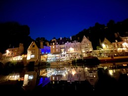 Magical evening atmosphere at Dinan Port with lights reflecting on the river