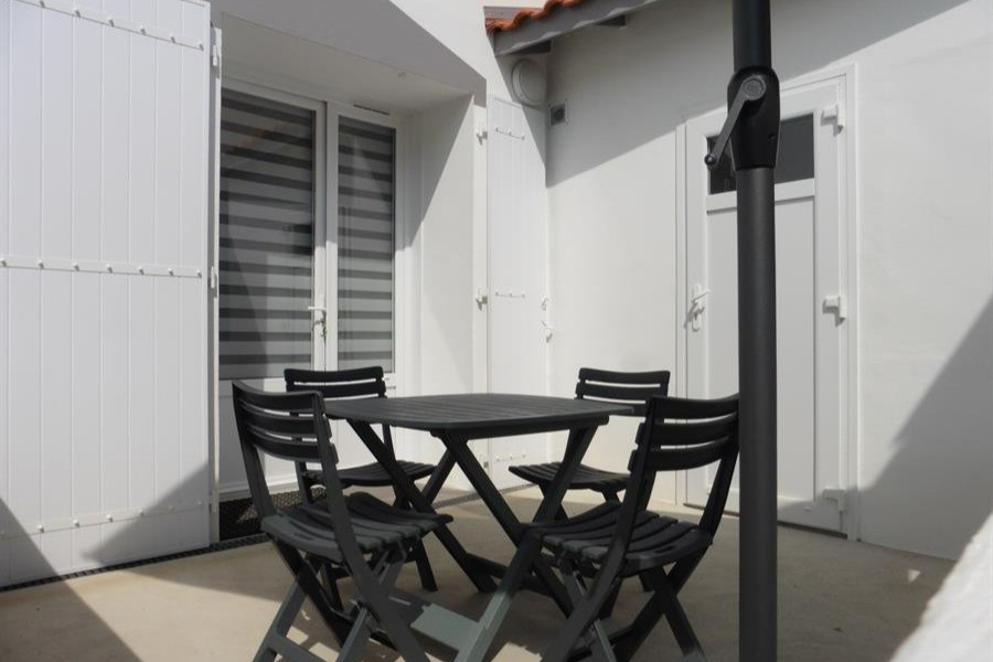 Terrasse avec salon de jardin et barbecue