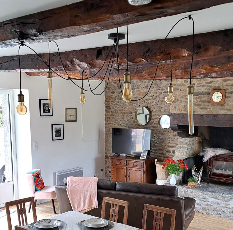 Grande pièce de vie au rez-de-chaussée avec espace cuisine ouverte, séjour et salon. Accès direct à la terrasse et au jardin clos par la baie vitrée.