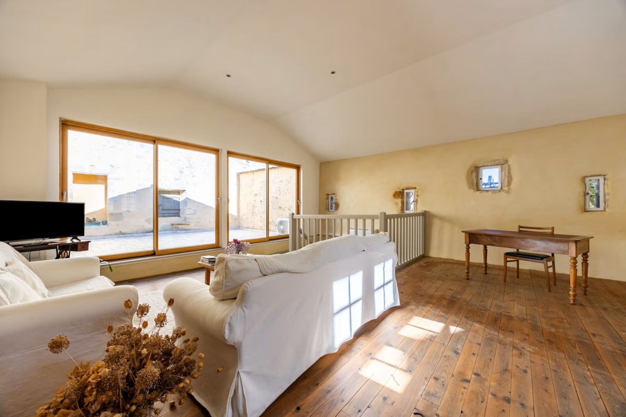 Au 1er étage le salon avec télévision et son bureau avec vue sur la terrasse privée de 30 m², à Bazas en Gironde