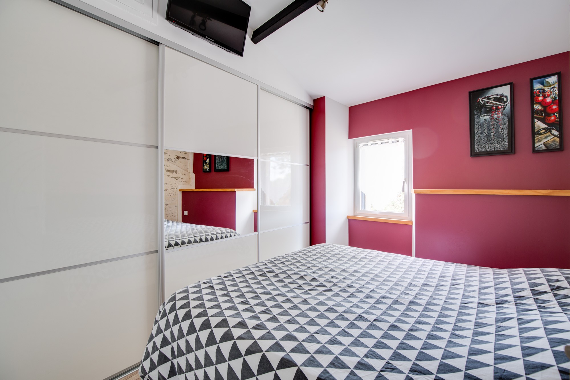 Chambre avec lit queen size et écran plat.