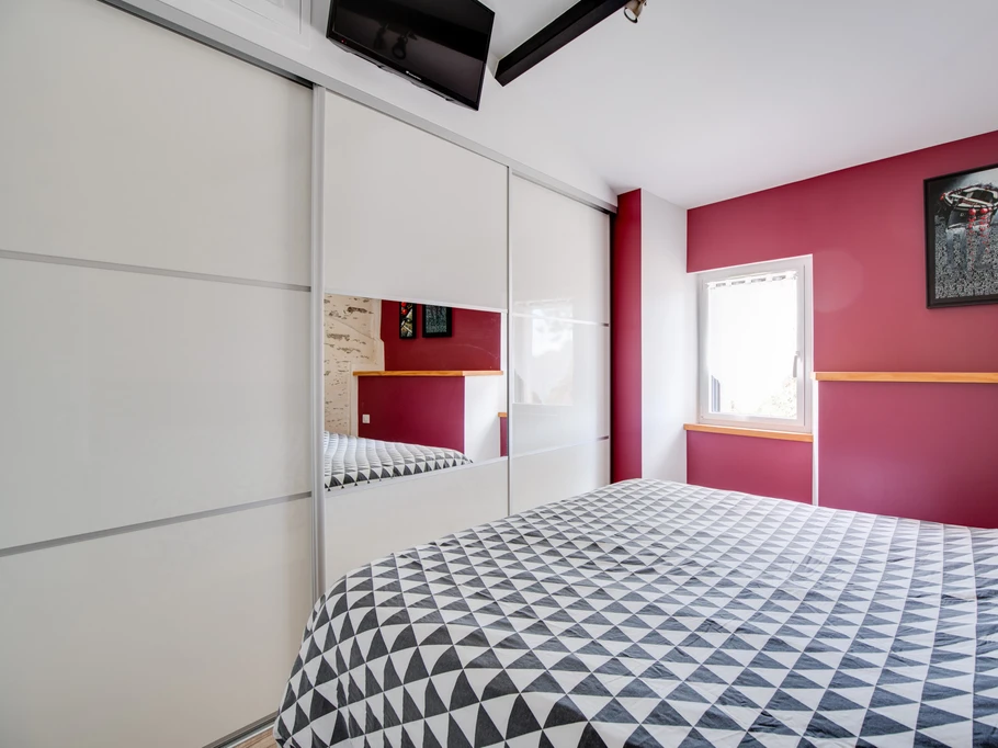 Chambre avec lit queen size et écran plat.