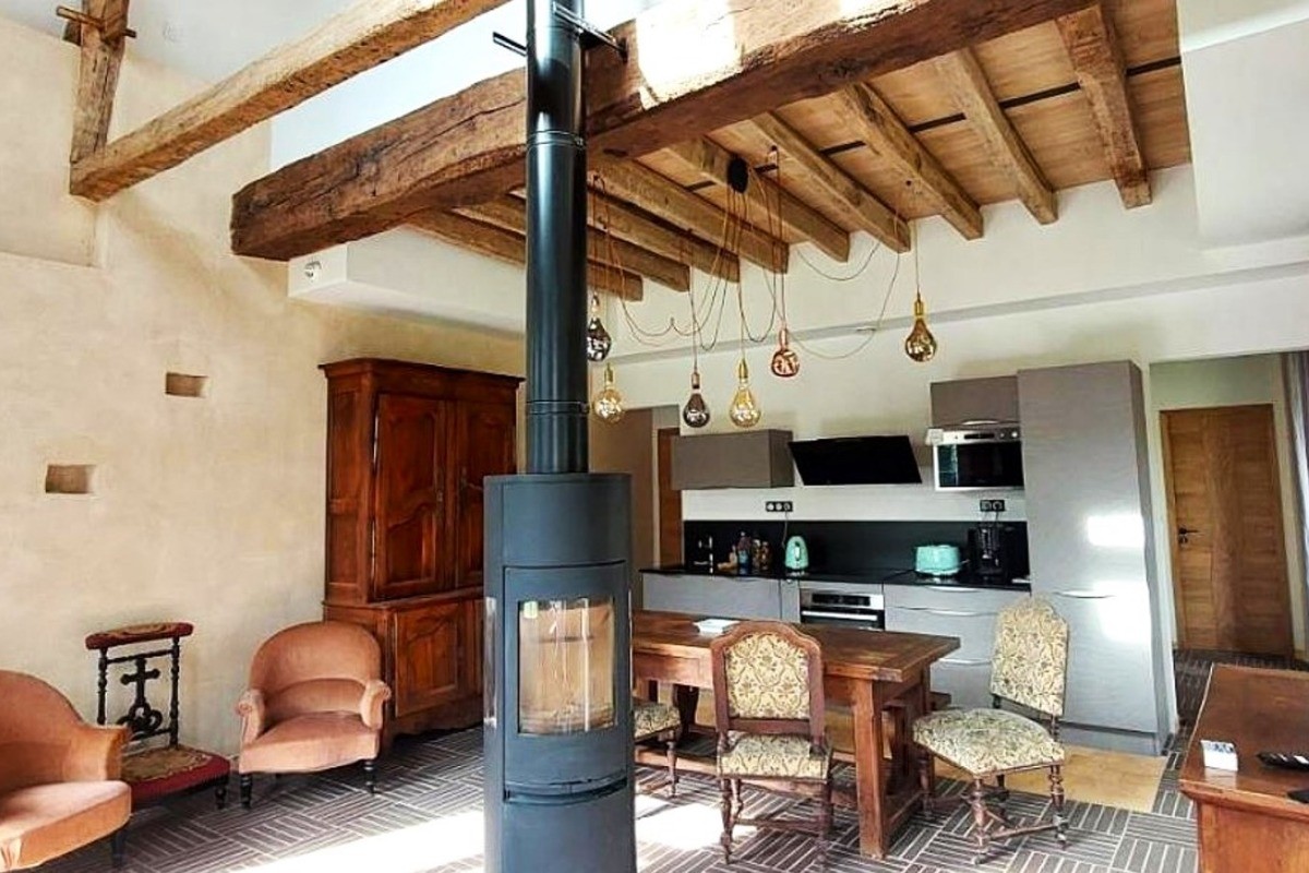 Pièce de vie en rez-de-jardin équipée d'un poêle à bois, avec espace salon, espace séjour et espace cuisine parfaitement équipée. Vaisselle haut de gamme fabriquée en France et électroménager de très bonne qualité.