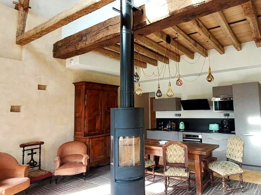 Pièce de vie en rez-de-jardin équipée d'un poêle à bois, avec espace salon, espace séjour et espace cuisine parfaitement équipée. Vaisselle haut de gamme fabriquée en France et électroménager de très bonne qualité.