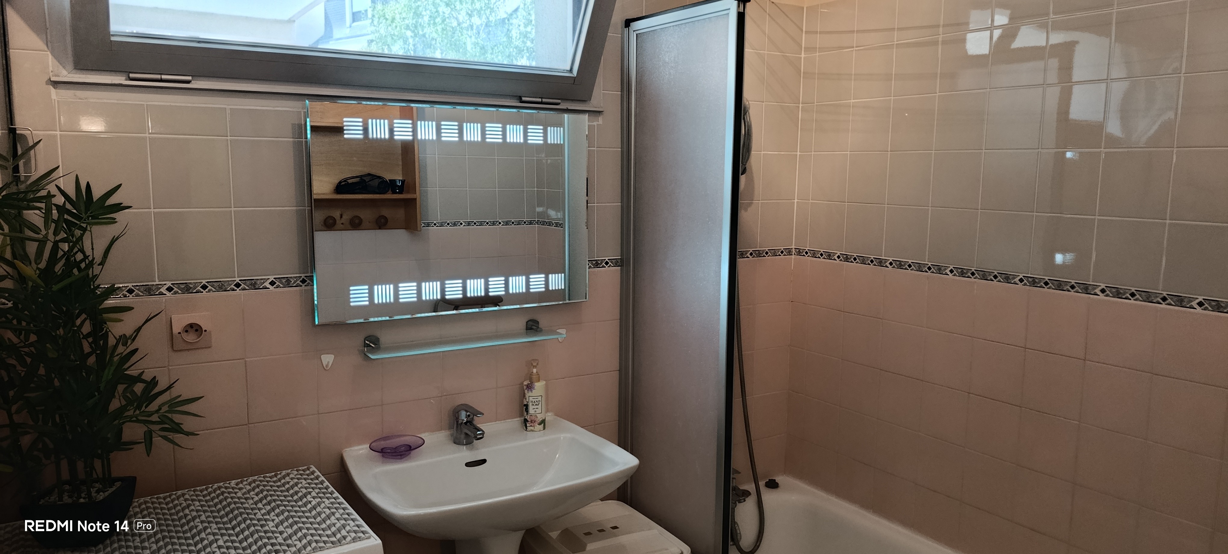 The bathroom with a bath, washing machine and storage shelves