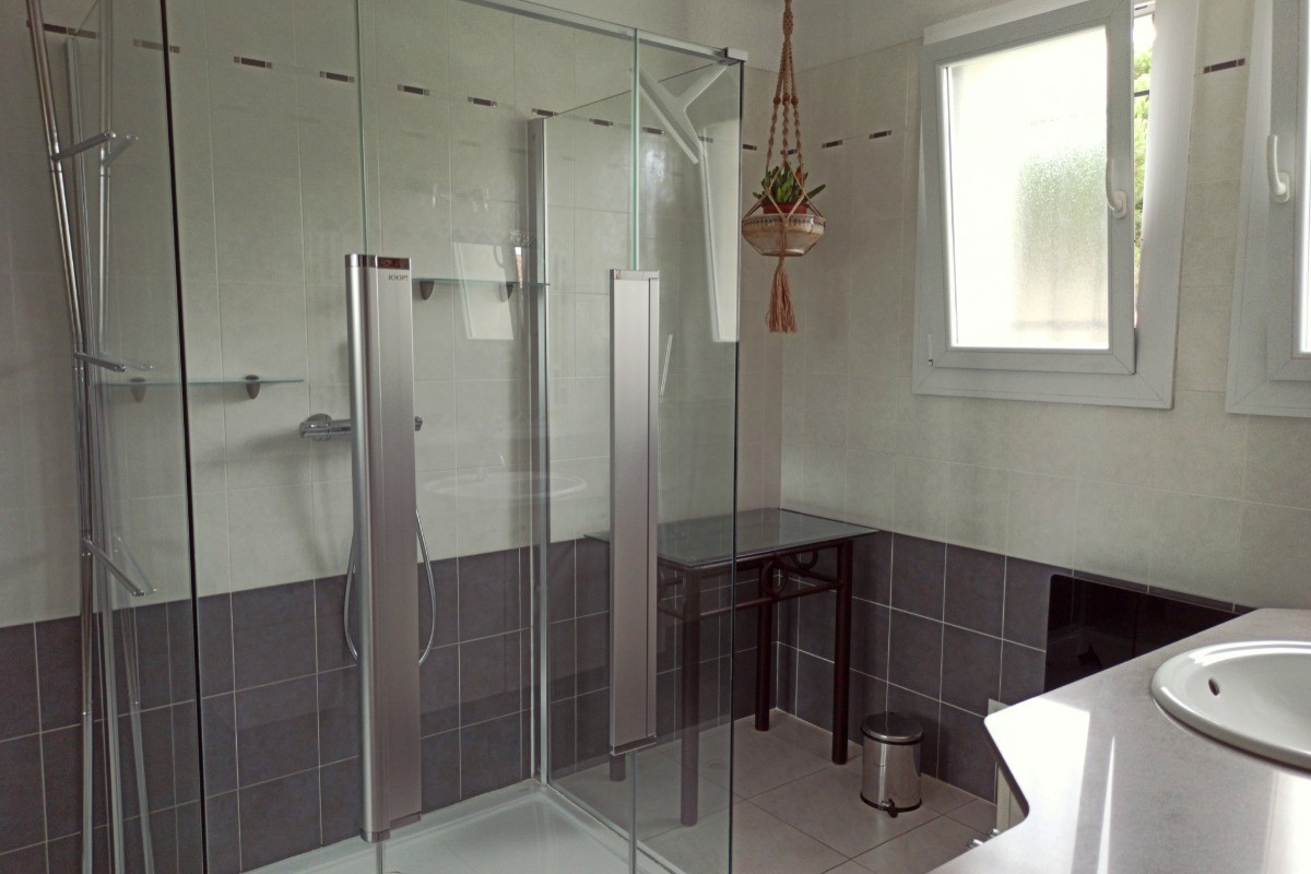 Salle de bain spacieuse avec grande cabine de douche