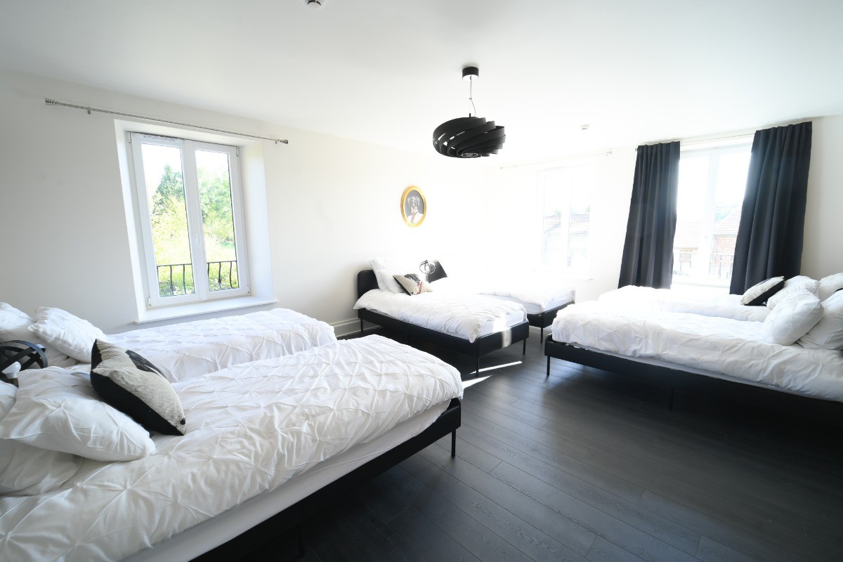 Une chambre avec 6 lits simples et sa SdB attenante