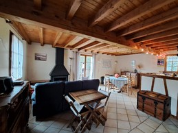 Le salon détente avec cheminée et le coin repas.