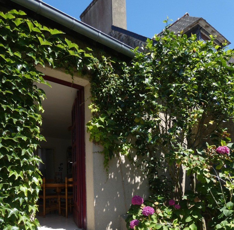 Façade de la maison fleurie au gré des saisons. Quelques marches pour accéder à la propriété puis à la location.