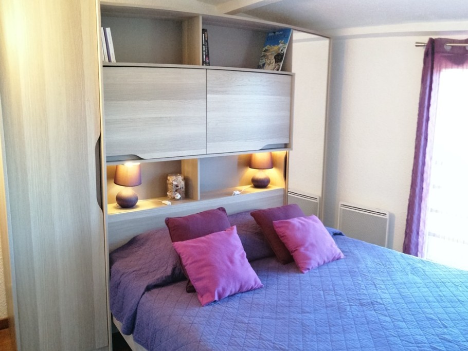 La chambre parentale climatisée, côté jardin, avec pont de lit avec penderie, placard, étagères et miroir.