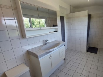 Grande salle de bain avec baignoire et douche du gîte Lilas